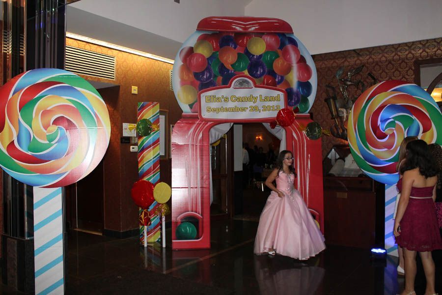 Entrance decorated with giant candy, girl in pink dress, party.