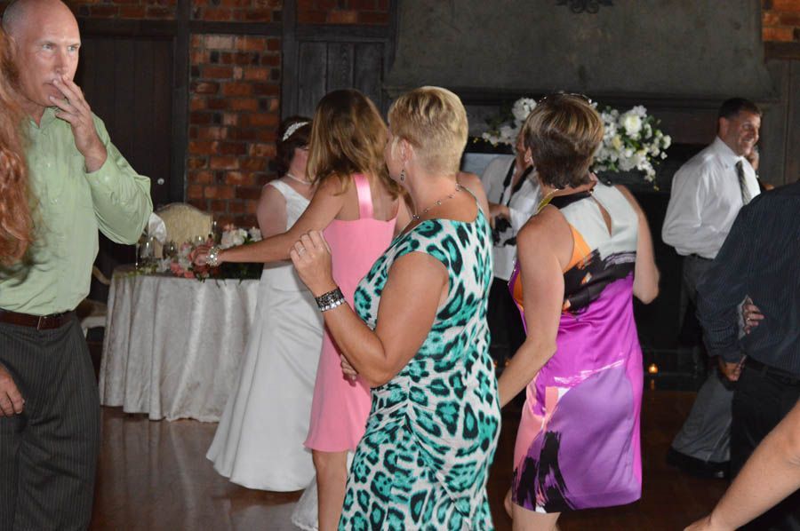 People dancing at a reception; a bride in white dress.