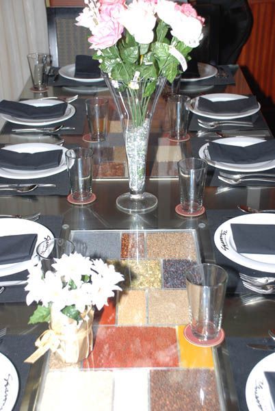 Formal table setting with flowers, black napkins, and glassware.