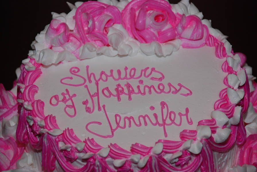 Cake with pink and white frosting, reads 
