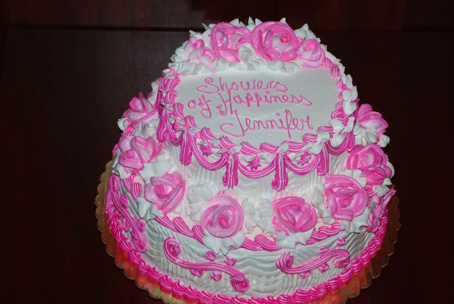 Two-tiered cake with pink and white frosting; inscription 