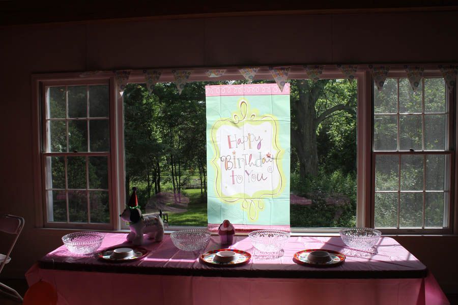 Party table set in front of a window with a banner that reads 