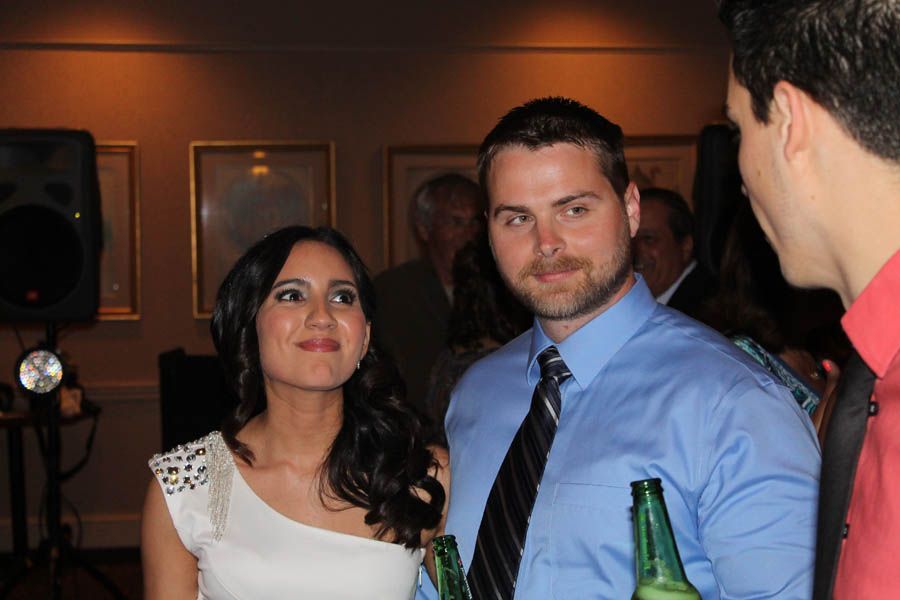 Woman in white dress and man in blue shirt and tie at an event.
