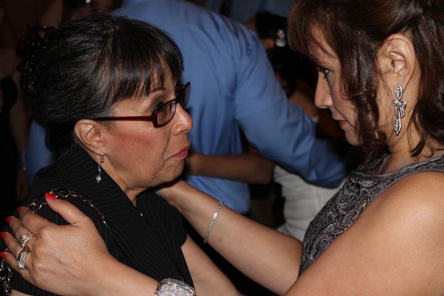 Woman comforting another; arms around shoulders. Close up.