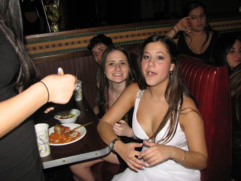 Group of people in a booth at a restaurant, one woman smiling at the camera.