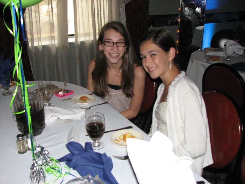 Two smiling people at a decorated table, possibly a celebration.