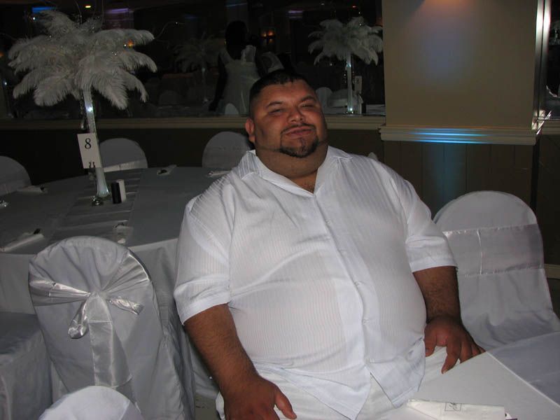 Man in white shirt sitting at a table with white decorations.