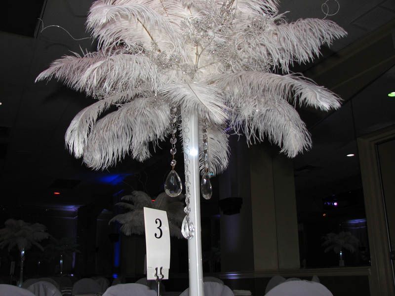 White feather centerpiece with hanging crystals; table number 3.