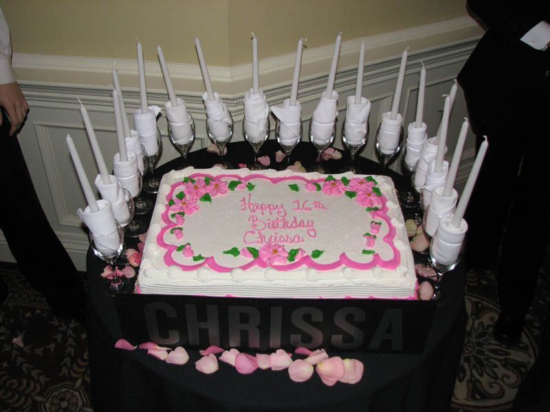 Birthday cake with pink frosting, surrounded by candles and 