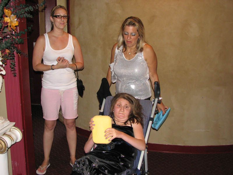 Woman in wheelchair with two women standing near her.