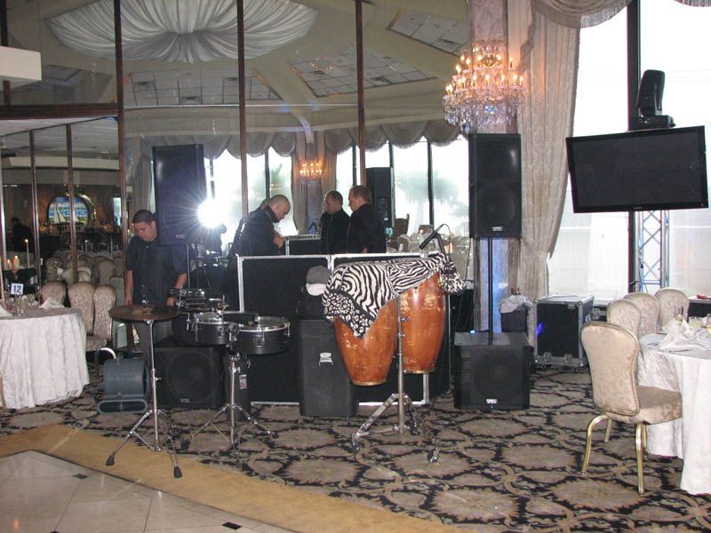 A band setting up equipment for a performance in a formal ballroom.