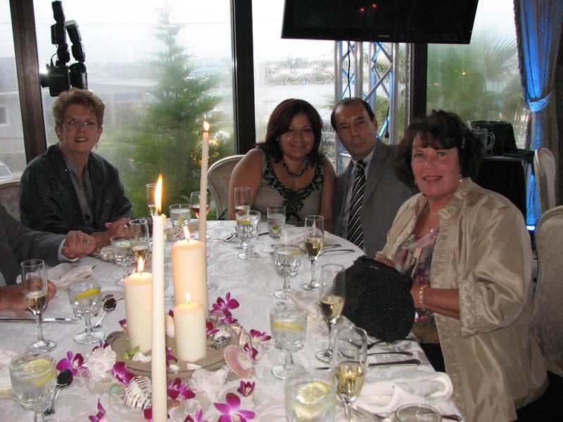 People seated around a table, decorated with candles and flowers; a formal setting with champagne.