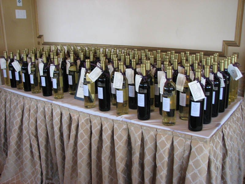Bottles of wine, labeled, arranged on a draped table, likely for tasting or sale.