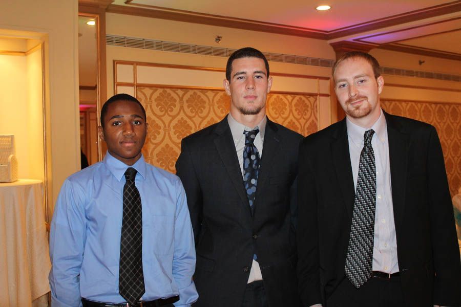 Three men in suits and ties standing indoors.