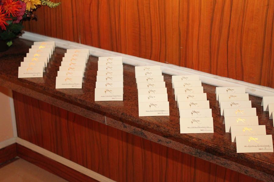 Stacks of cream-colored cards with gold accents arranged on a wood-grain surface.