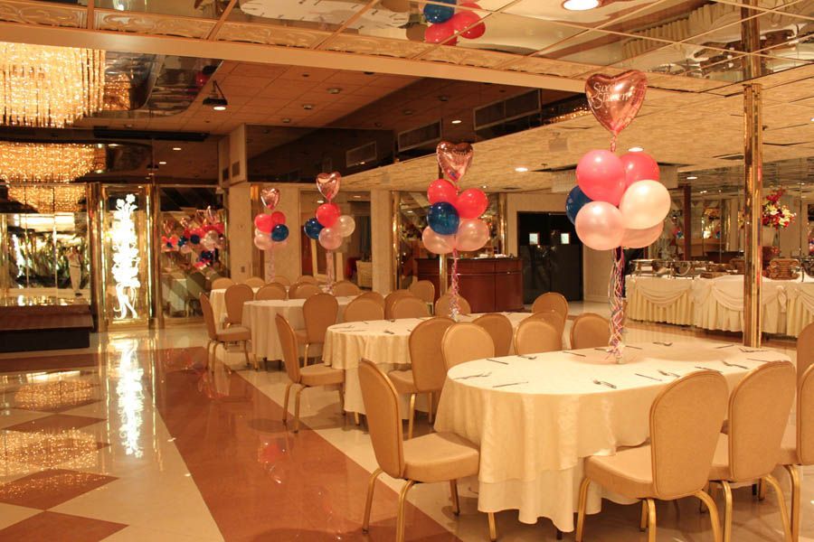 Ballroom with round tables, chairs, balloons. Shimmering ceiling and flooring.