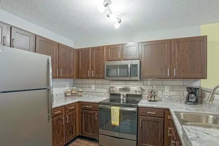 Kitchen with brown cabinets, stainless steel appliances, and granite countertops.