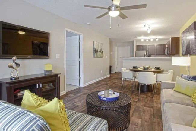 Living room with couch, TV, dining table, and open kitchen.