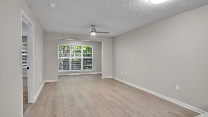 Living room with couch, TV, dining table, and open kitchen.