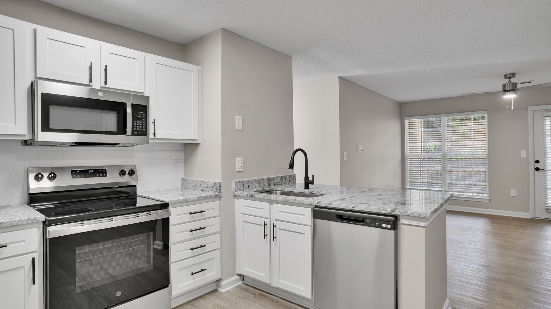 Kitchen with brown cabinets, stainless steel appliances, and granite countertops.
