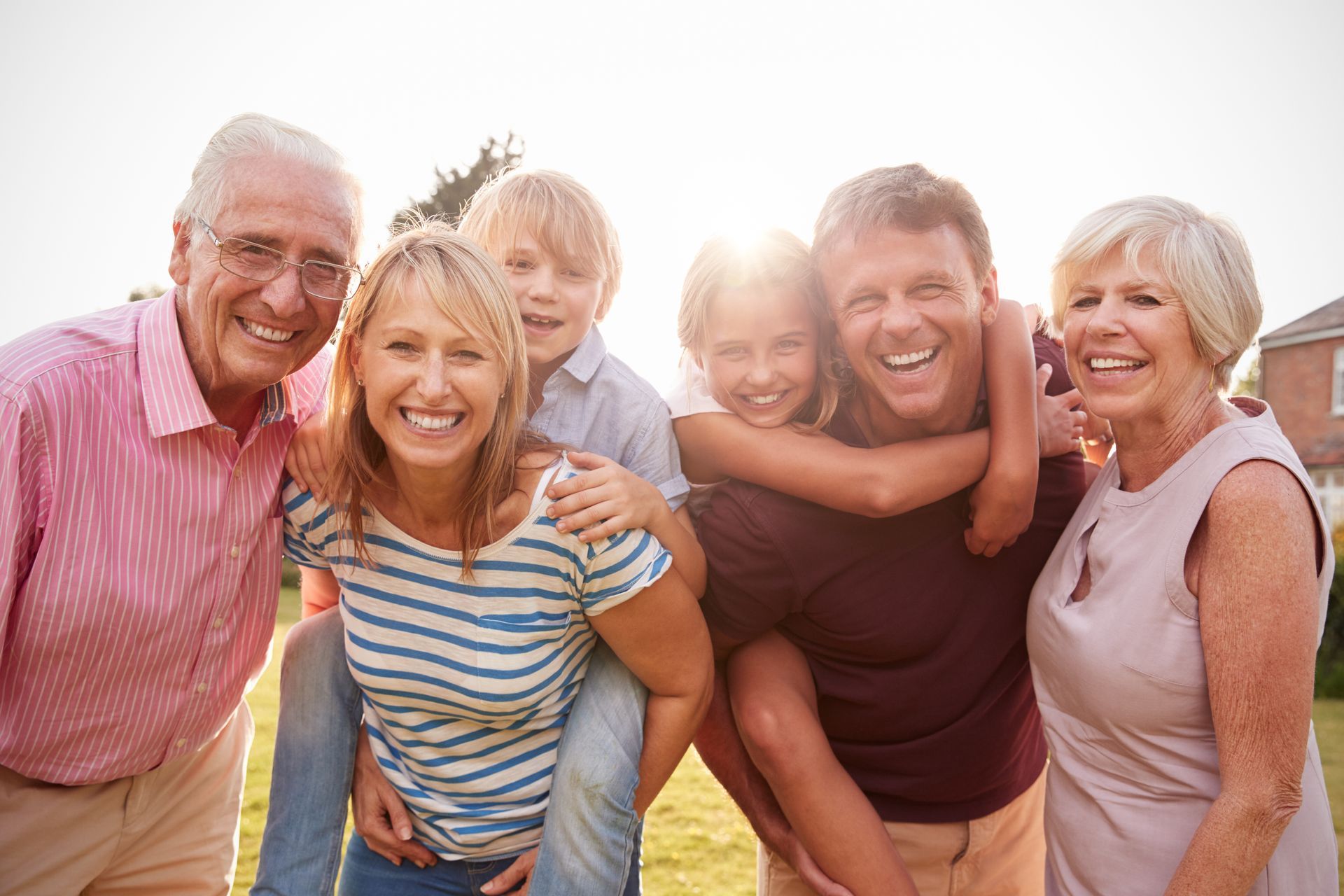 A large family is posing for a picture together in a park.