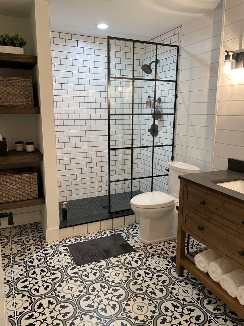 A bathroom with a toilet , sink and walk in shower.