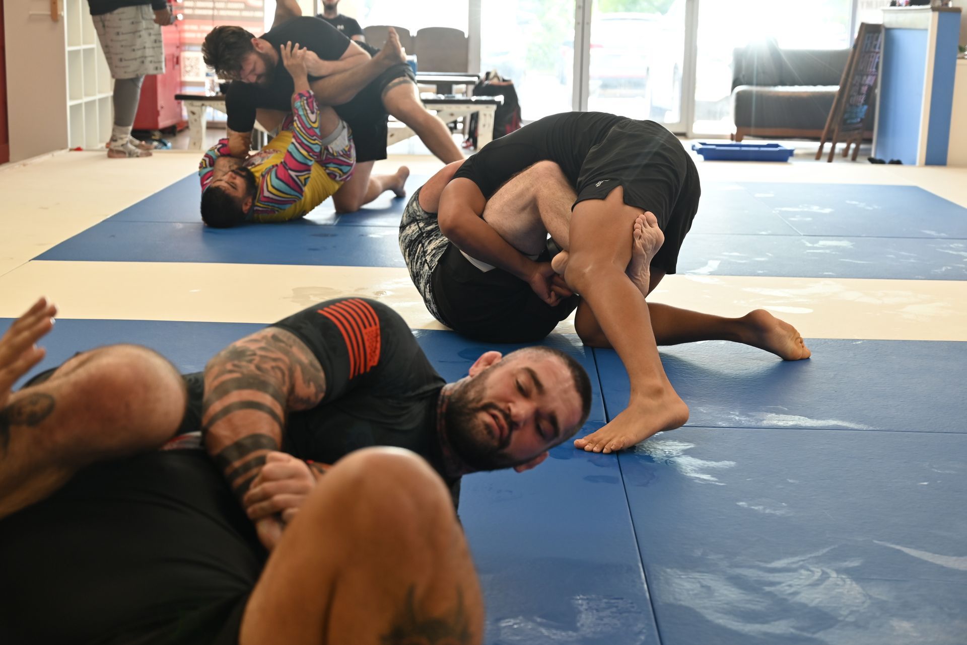 Adults training Brazilian Jiu-Jitsu at B-52 Jiu-Jitsu Academy in Perry building focus, and fitness.