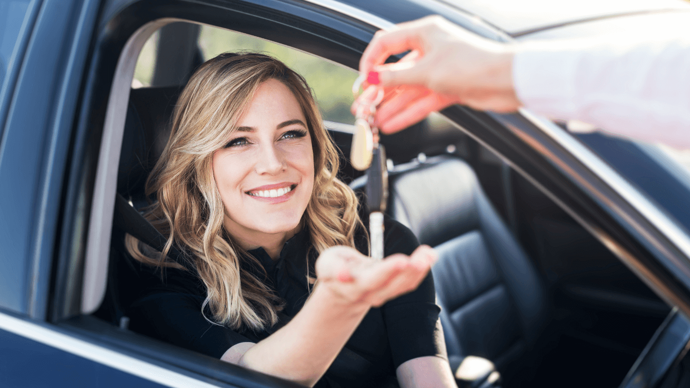person purchasing a new car being handed the keys