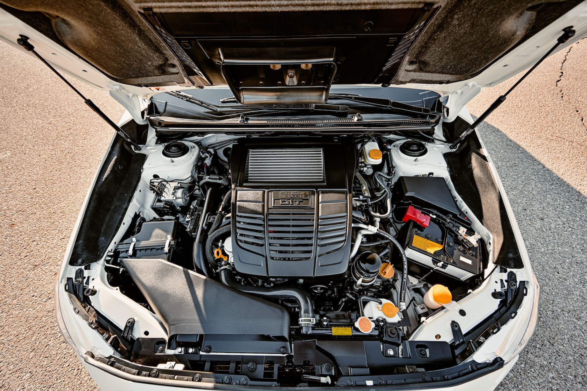 The engine of a white car with the hood open