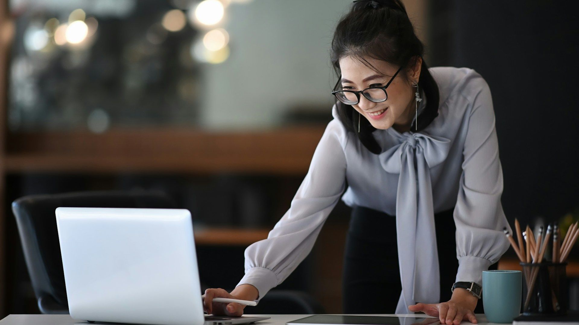 woman working on a laptop while standing
