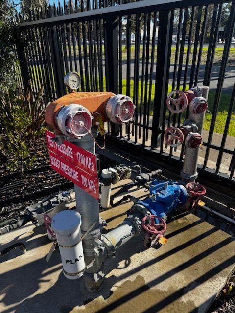 Electrician in black gloves, working on electrical panel with a screwdriver.