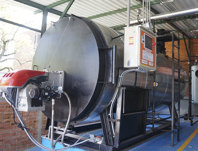 Una caldera grande está ubicada debajo del techo de un edificio.
