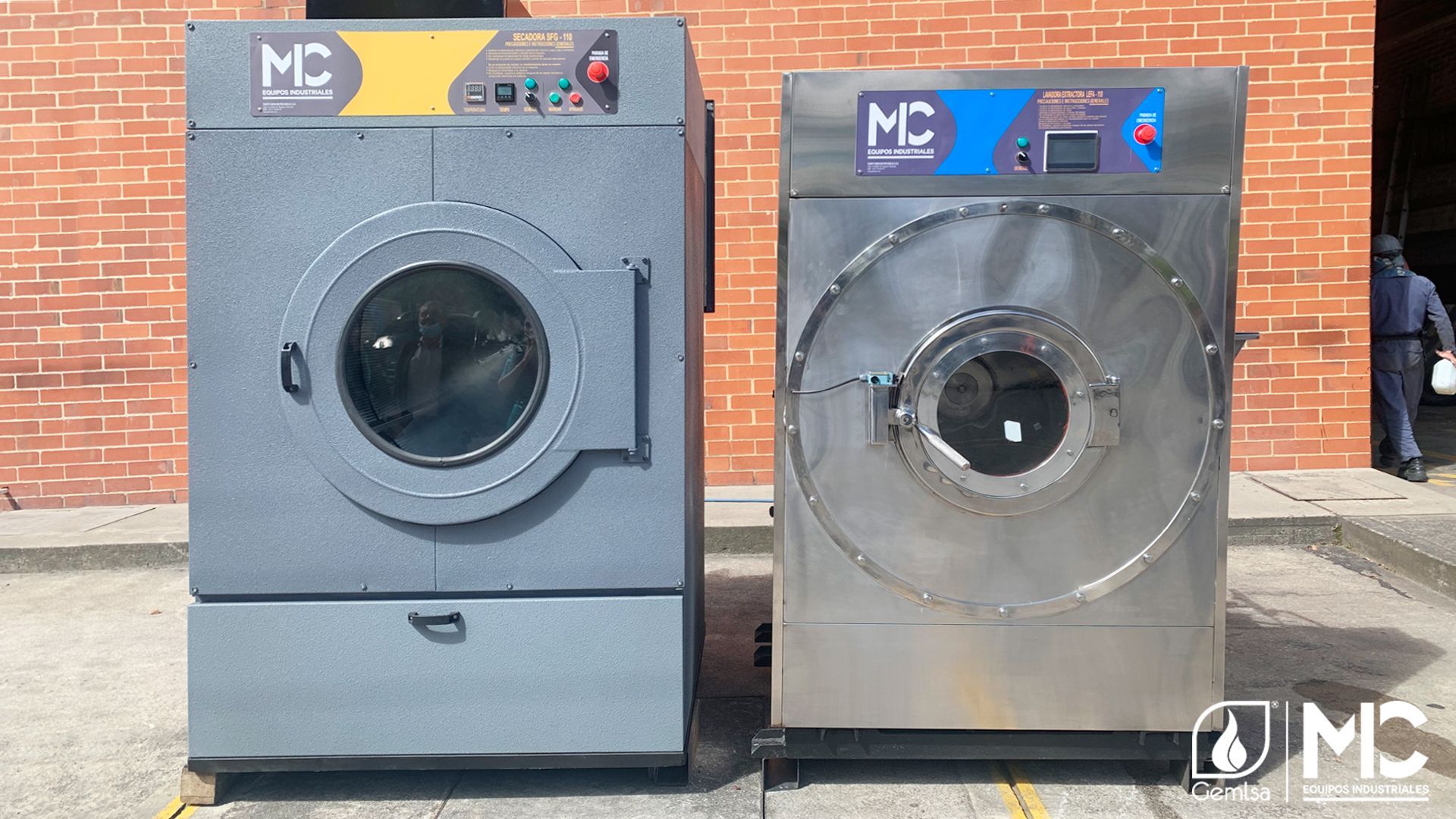 Dos máquinas de lavandería comerciales, una gris y otra de acero inoxidable.