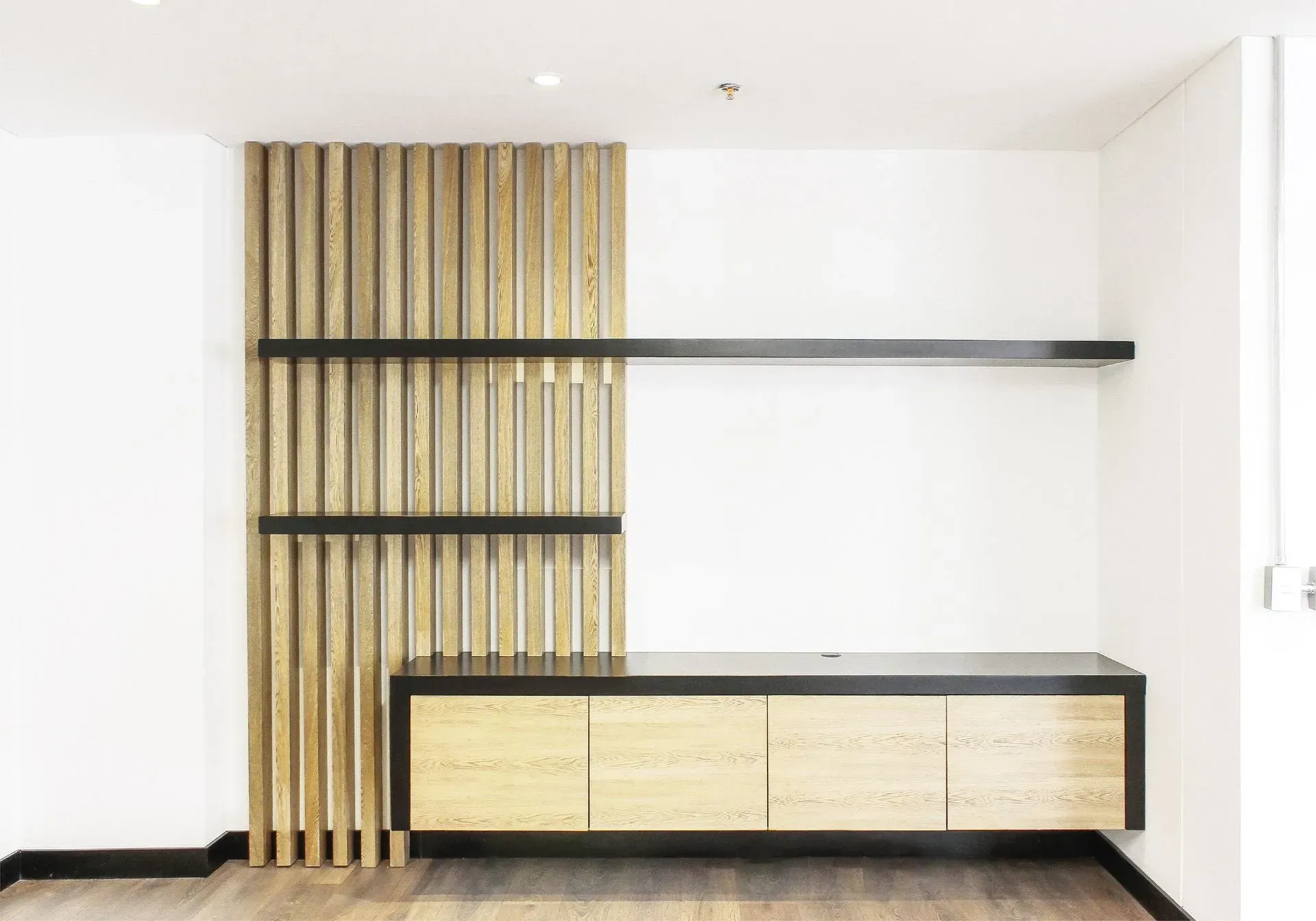 Pared con listones de madera, estantes y un armario en una habitación moderna y minimalista.
