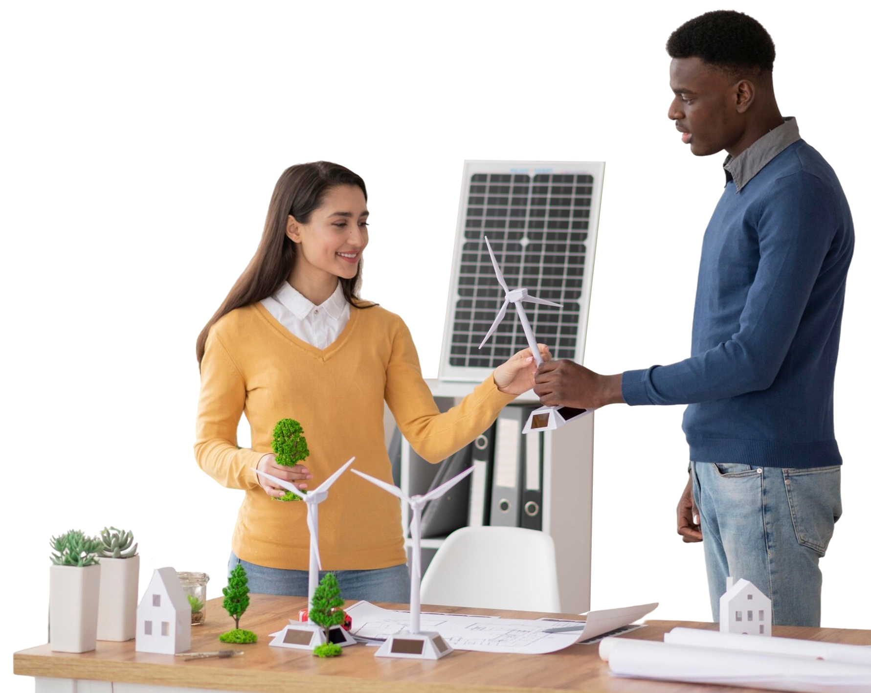 Dos personas trabajando en una maqueta con panel solar y turbinas eólicas en un escritorio, sonriendo.