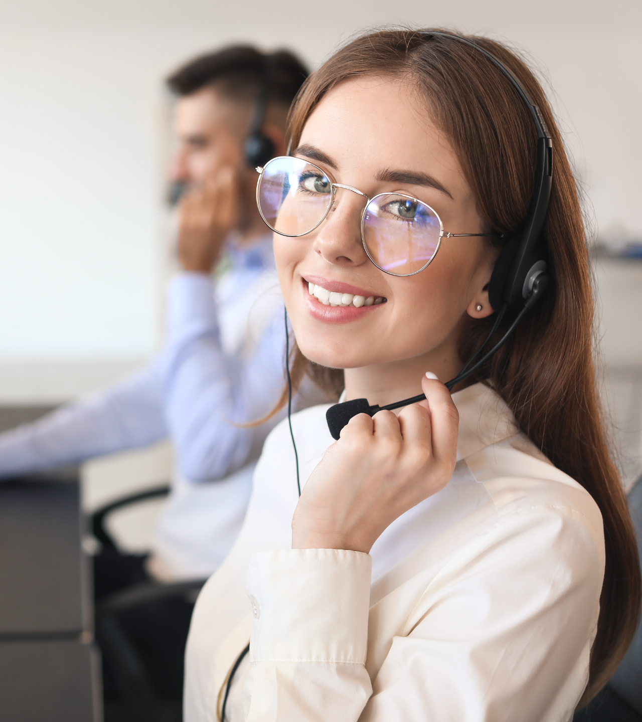 A family is sitting in a grassy field with mountains in the background.