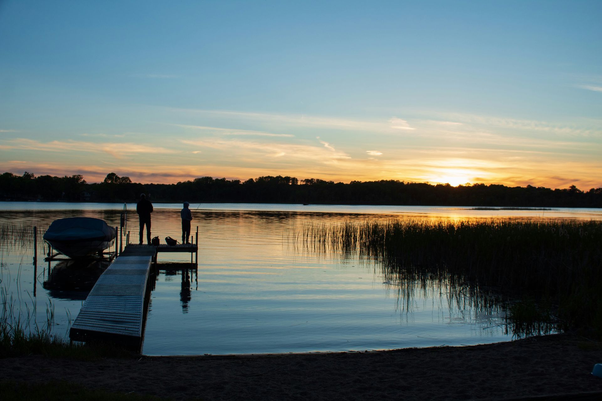 Man in plaid shirt smiles at child from car window.