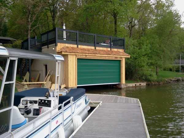 A boat is docked at a dock next to a green garage door