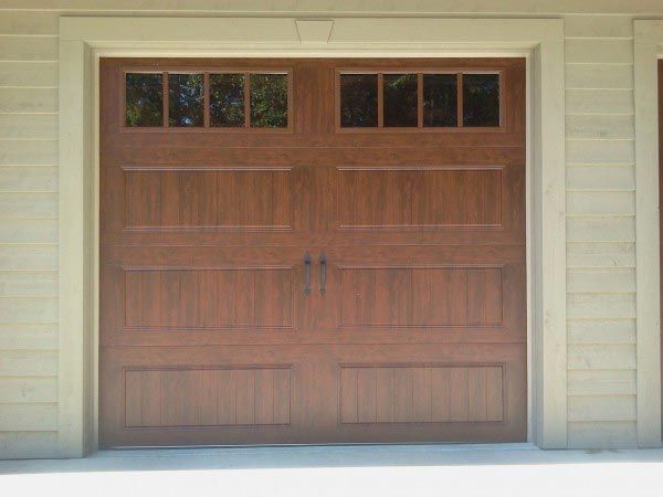 A wooden garage door with a window on it