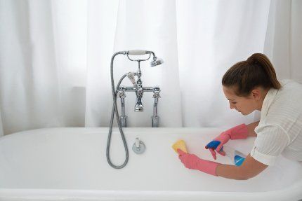Professional cleaner cleaning a bathtub and whole house with her team, hired by the homeowner who's planning to sell her home in Bunbury WA.