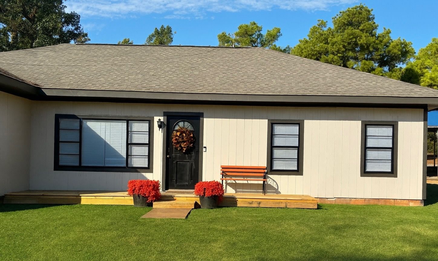 Tan-colored house with black trim and a gray roof.
