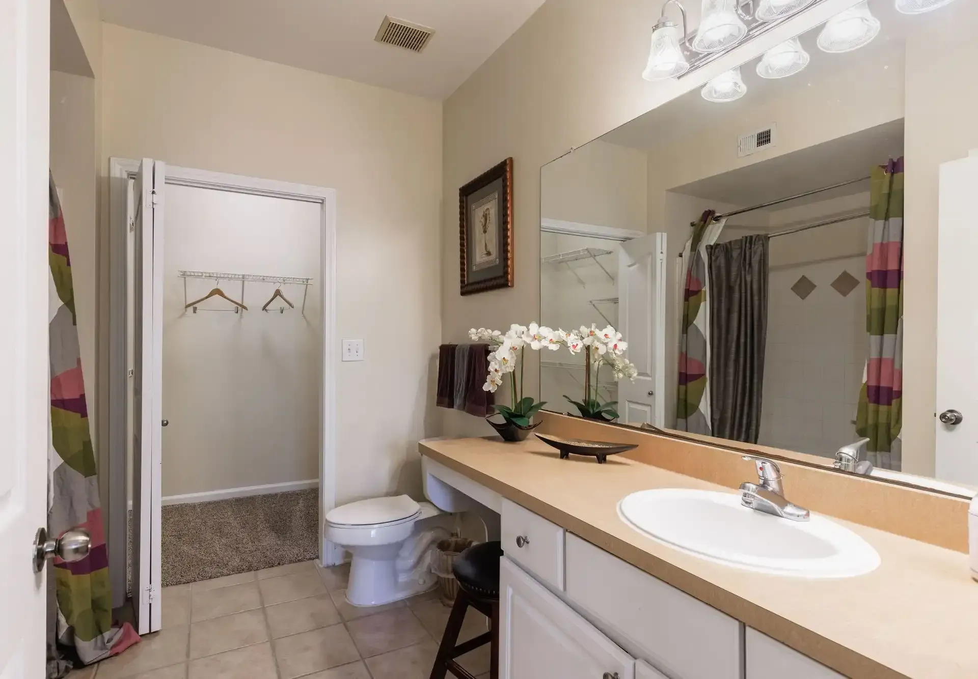 Bathroom with beige countertop, white sink, toilet, and shower.