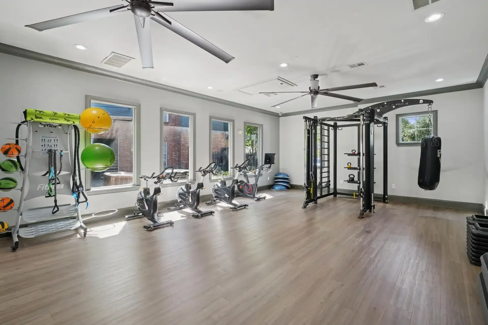 Gym with spin bikes, exercise equipment, and large ceiling fans.