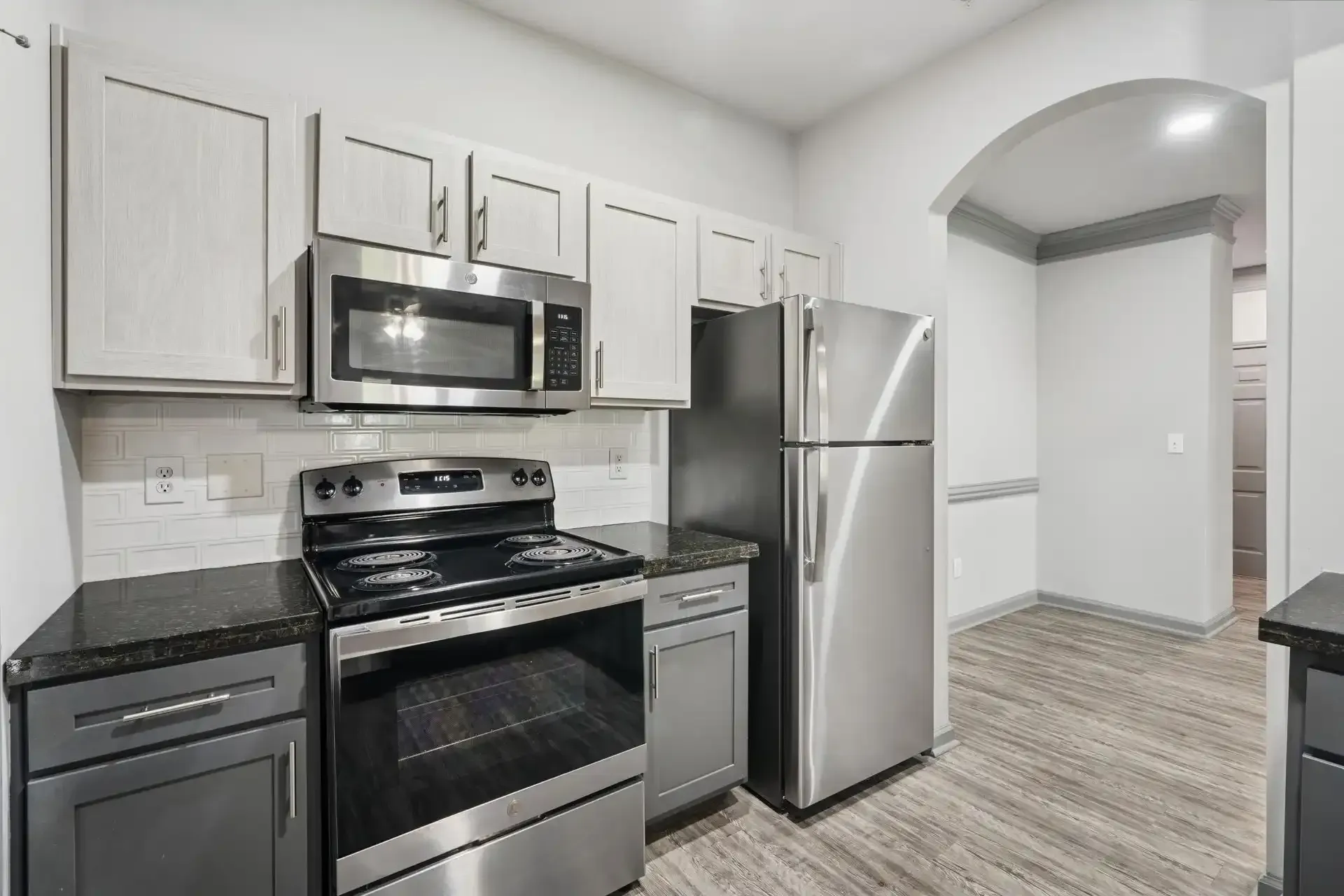 Modern kitchen with stainless steel appliances, gray cabinets, and granite countertops.