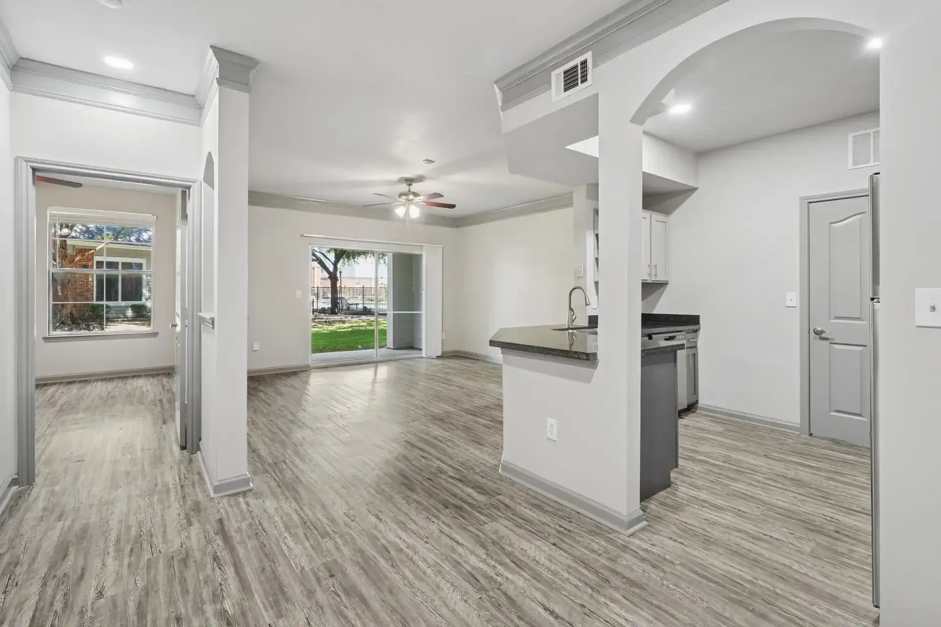 Bright living space with gray floors, white walls, and a view of the outdoors.