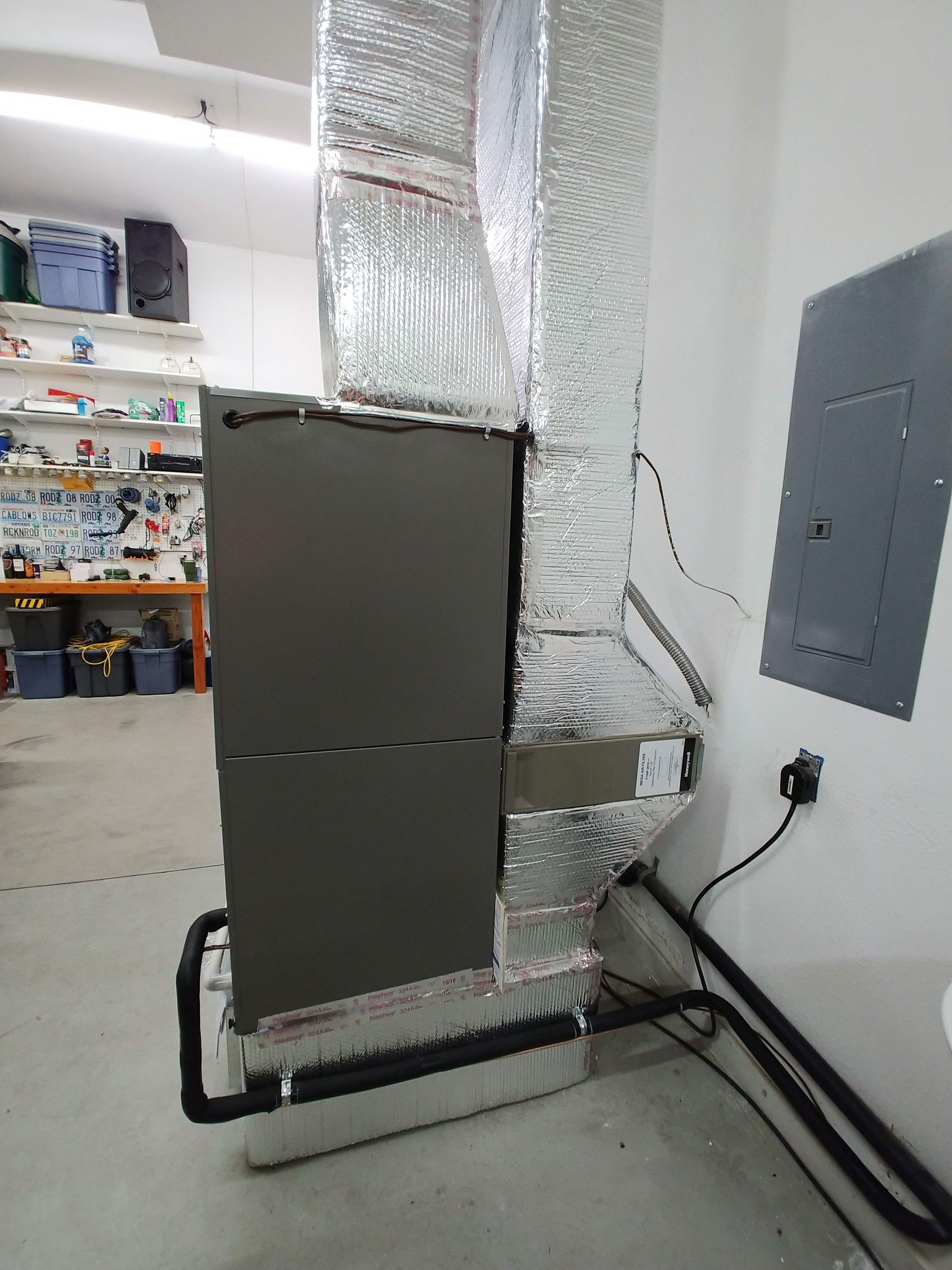 A refrigerator is sitting in a garage next to a wall.