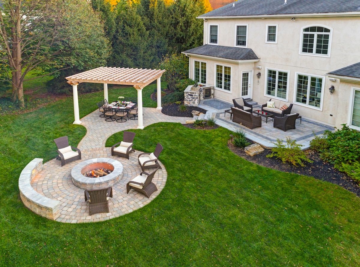 An aerial view of a backyard with a fire pit and patio furniture.