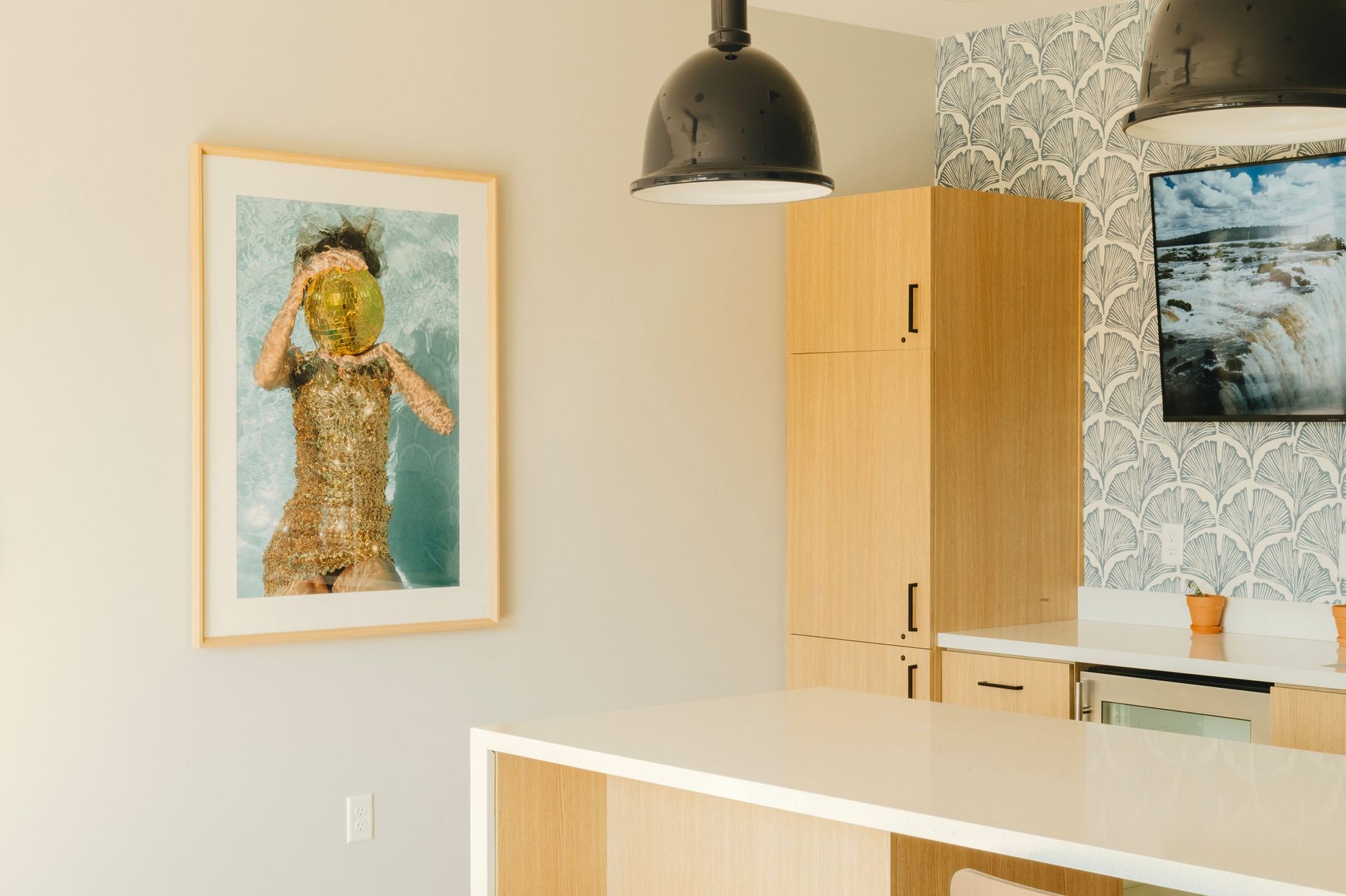 A modern kitchen with art. A person floating in water wearing a mask. White countertop at Revelry in Madison WI.