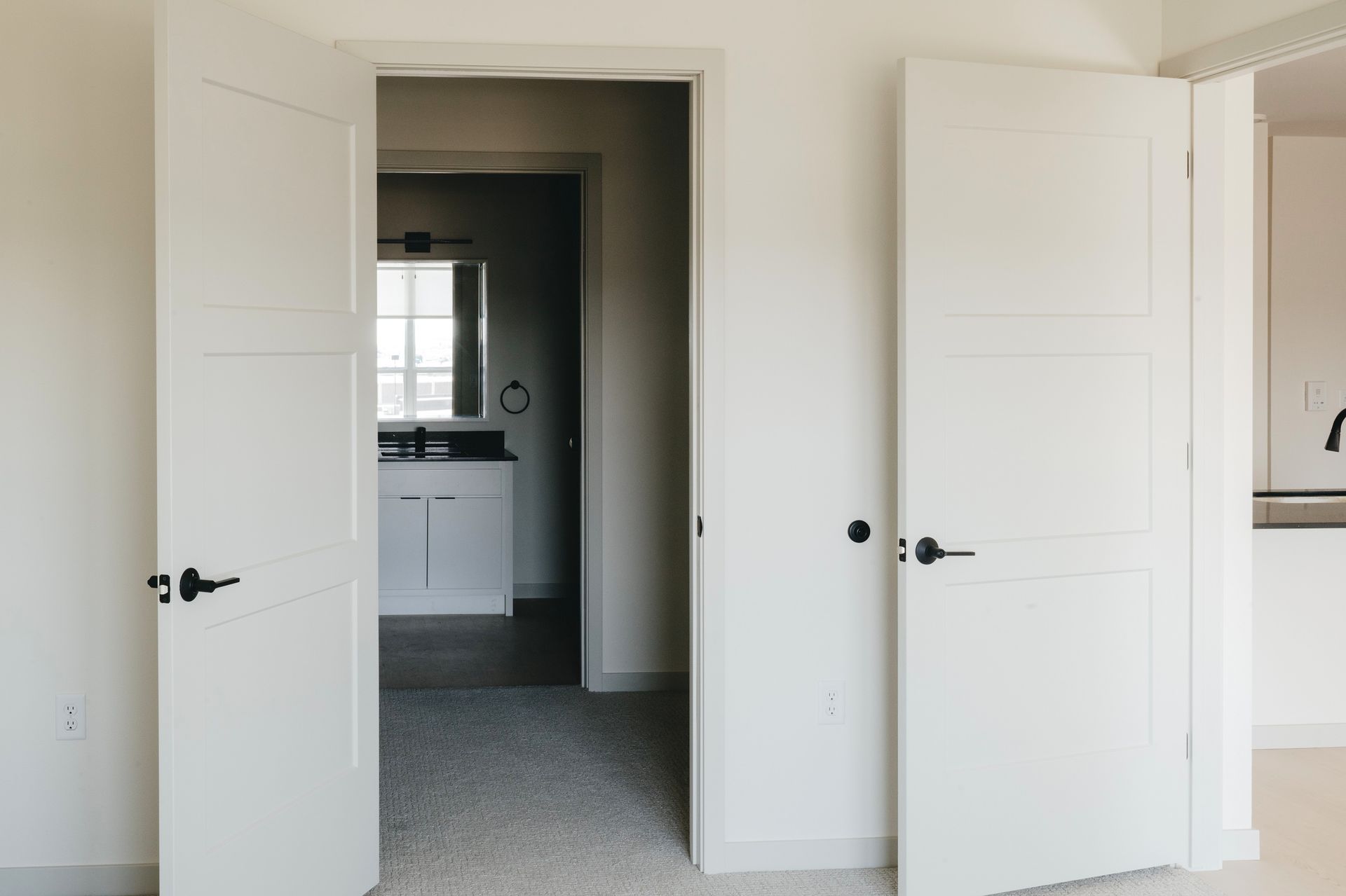 White double doors open to a bathroom at Revelry in Madison WI.