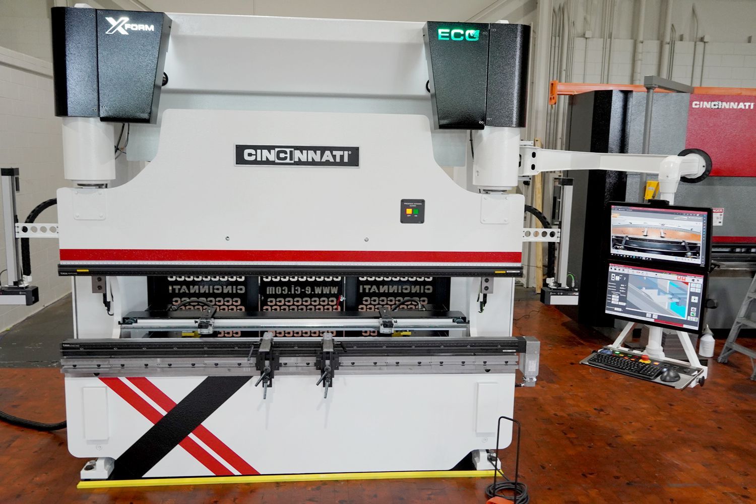 Large white Cincinnati press brake machine with red and black accents in a factory setting.